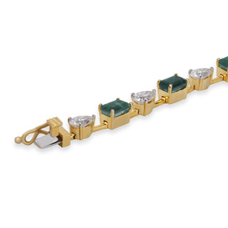 Gold bracelet with green and clear gemstones on a white background