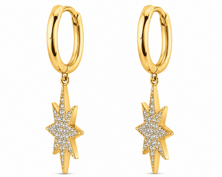 A pair of gold huggie hoop earrings with dangling starburst charms paved with clear stones, shown on a plain white background.