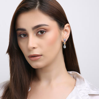 Woman wearing earrings with a plain background